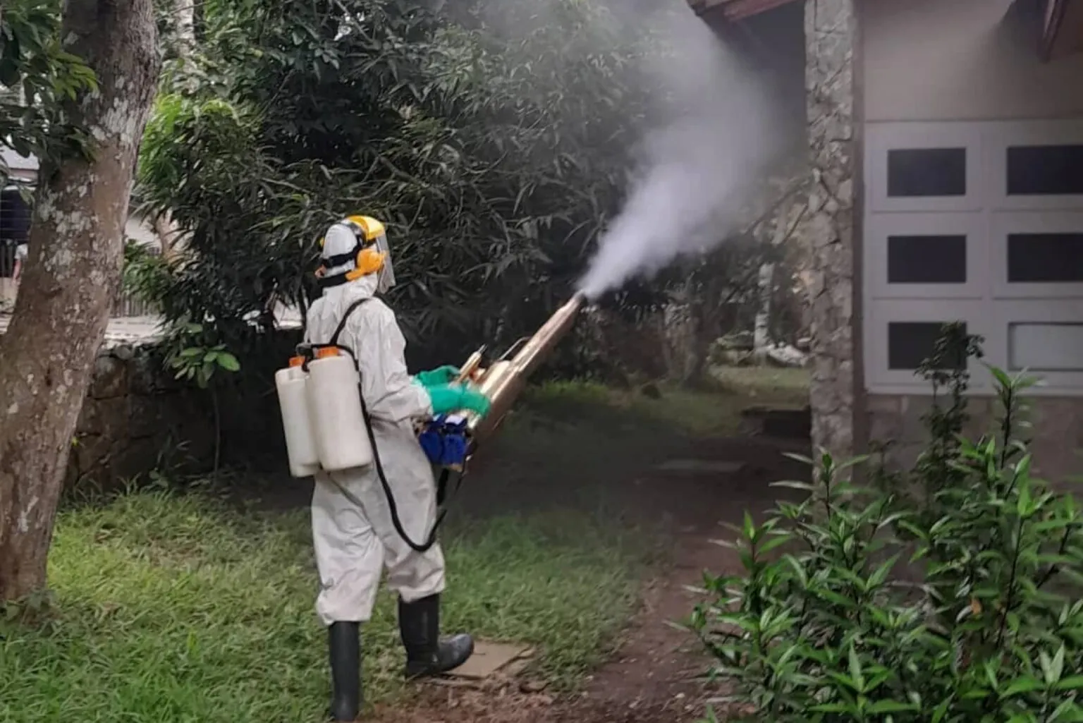 JuKaro technician in protective suit fogging a residential compound